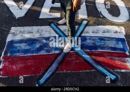 Bab al Hawa, Siria. 17 luglio 2023. Un manifestante si trova sui graffiti con la bandiera russa e la parola veto durante una protesta nei pressi del confine di Bab al-Hawa con la Turchia contro la sospensione delle consegne di aiuti attraverso Bab al-Hawa. Credito: Anas Alkharboutli/dpa/Alamy Live News Foto Stock