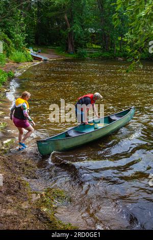 Coppia che lancia una canoa per una pagaia sul lago Sparrow nel distretto di Muskoka, Ontario, Canada Foto Stock