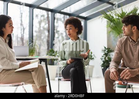 Team aziendale impegnato nel lavoro di squadra e discussione mirata in ufficio Foto Stock