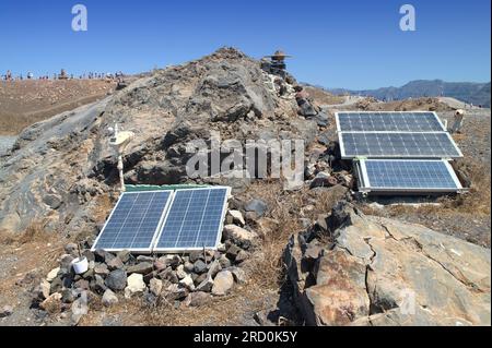 Pannelli fotovoltaici che alimentano una stazione meteorologica e sismica sul vulcano Santorini. Foto Stock
