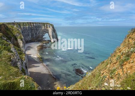 Étretat è meglio conosciuta per le sue scogliere di gesso, tra cui tre archi naturali e una formazione appuntita chiamata l'Aiguille o gli aghi Foto Stock