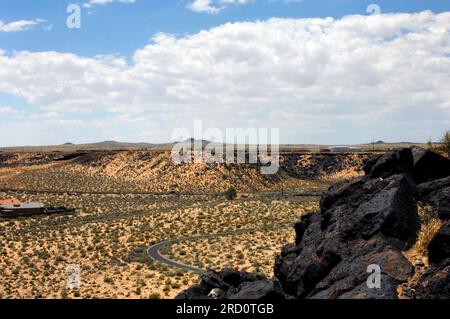 Petroglyph National Monument view includes distant cinder cones of dormant volcanoes just outside of Albuquerque.  Basalt rocks in forground containt Stock Photo