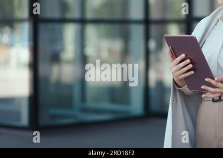 Primo piano della mano di una donna d'affari che utilizza un tablet: Tecnologia, social network, concetto di lavoro digitale, spazio di copia Foto Stock