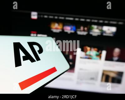 Cellulare con logo dell'agenzia di stampa statunitense Associated Press (AP) sullo schermo davanti al sito Web. Mettere a fuoco il display centrale sinistro del telefono. Foto Stock