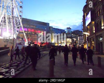 Gli ufficiali della polizia di Greater Manchester parlano con i tifosi di calcio nei bar di una trafficata Exchange Square, nel centro di Manchester, nel Regno Unito, prima del Manchester United vs Ajax UEFA Europa League Round del 32, tenutosi all'Old Trafford, giovedì 23 febbraio 2012. L'atmosfera è tesa. Il MUFC ha continuato a perdere la partita, ma sono comunque avanzati aggregati per prenotare un ultimo pareggio di Europa League 16. La polizia è preoccupata di tenere i fan lontani dal centro di intrattenimento Printworks, quindi formate una fila. Il Manchester United ha raggiunto la finale 16 dell'Europa League vincendo 3-2 in totale, nonostante abbia perso 2-1 contro l'Ajax. Foto Stock