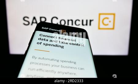 Smartphone con pagina Web del software di gestione delle spese SAP sullo schermo davanti al logo aziendale. Mettere a fuoco in alto a sinistra sul display del telefono. Foto Stock