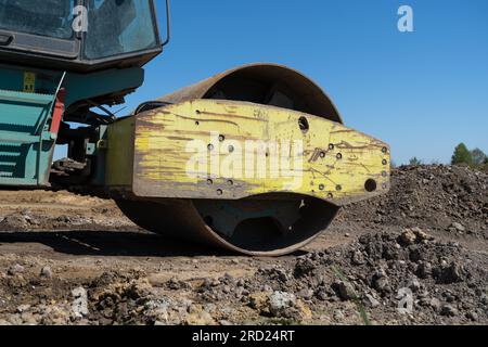 Compattatore per terreno, rullo stradale a tamburo singolo nel cantiere di un'autostrada. Foto Stock