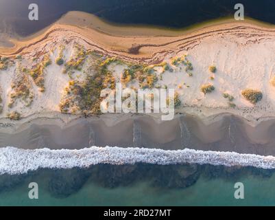 Vista aerea delle onde che si gettano su una spiaggia di uno stretto bar di sabbia sull'Isola dei cigni a Queenscliff a Victoria, Australia Foto Stock