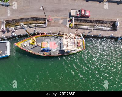 Vista aerea di un peschereccio legato a un molo con un'utenza parcheggiata accanto a Port Fairy, Great Ocean Road, Victoria, Australia. Foto Stock