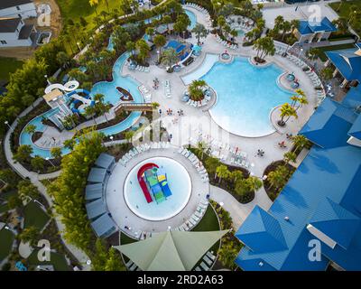 Guardando in basso le piscine di una club House del resort con scivoli acquatici e sedie per rilassarsi in Florida. Foto Stock