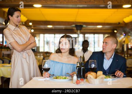 Triangolo d'amore - moglie ha preso marito con la padrona nel ristorante Foto Stock