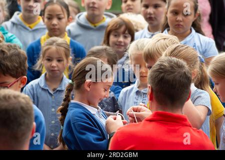 Boveney, Buckinghamshire, Regno Unito. 18 luglio 2023. I bambini della Eton Wick CofE First School nel villaggio di Eton Wick, Windsor, Berkshire, sono venuti a incontrare i cigni a Boveney Lock sul Tamigi nel Buckinghamshire questa mattina. Hanno imparato come le tomaie del cigno si uniscono ai piedi del cigno quando li esaminano. Credito: Maureen McLean/Alamy Live News Foto Stock