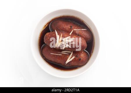 Primo piano del tradizionale piatto dolce indiano di Bangali Pitha o Peetha ( Roshopuli ) a base di patate dolci rosse, guarnite con mandorle tritate e noci secche Foto Stock
