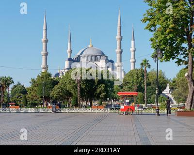 Parco Sultanahmet e Moschea Sultan Ahmed, nota anche come Moschea Blu, in una mattinata estiva, Istanbul, Turchia. Red cart vende Simits, alias bagel turchi Foto Stock