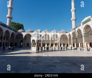 I visitatori del Sahn aka Courtyard della Moschea del Sultano Ahmed alias Moschea Blu in una mattina estiva a Istanbul, Turchia Foto Stock