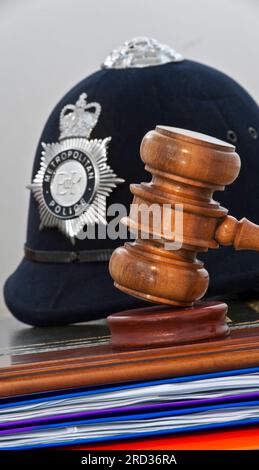 PROVE DELLA POLIZIA GAVEL GIURAMENTO DELLA CORTE SENTENZA concetto legale casco della polizia metropolitana con martello martello martellante dei giudici in tribunale di Londra concetto UK Foto Stock