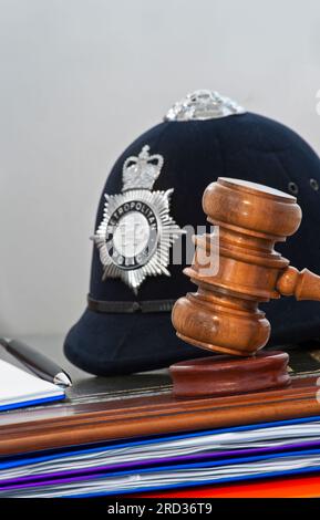 PROVE DELLA POLIZIA GAVEL GIURAMENTO DELLA CORTE TACCUINO PENNARELLO SENTENZA concetto legale casco della polizia metropolitana con i giudici gavel nei tribunali di Londra situazione Regno Unito Foto Stock