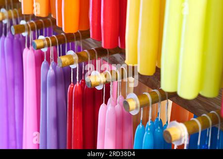 Ampio gruppo di candele multicolore assortite in cera, vista diagonale, sfondo astratto e vivace Foto Stock