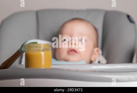 Vasetto con coperchio per purea di verdure sullo sfondo del bambino. Il concetto di nutrire i bambini, vitamine negli alimenti. Foto Stock