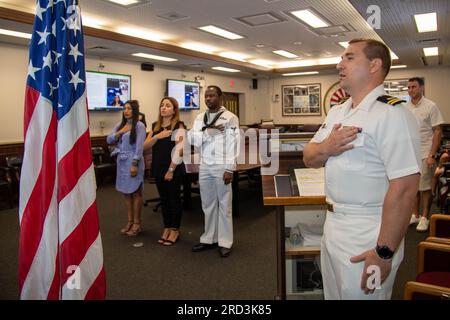 I marinai e i membri della famiglia con sede a Sasebo recitano il Pledge of Allegiance of the United States of America durante una cerimonia di naturalizzazione presso Commander, Fleet Activities Sasebo (CFAS) il 29 giugno 2023. STATI UNITI Citizenship and Immigration Services and Region Legal Service Office Western Pacific ha collaborato per condurre la cerimonia di naturalizzazione presso CFAS consentendo ai marinai di diventare cittadini degli Stati Uniti. Foto Stock