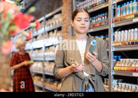 La cliente femminile sceglie i pigmenti multicolore per il suo futuro vasellame di terracotta o ceramica in un negozio specializzato Foto Stock