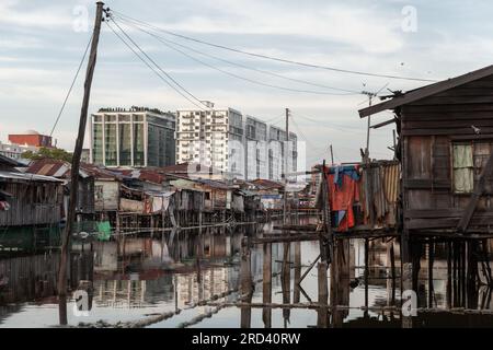 Kota Kinabalu, Malesia. Case residenziali povere e ricchissime e ponti pedonali su palafitte Foto Stock