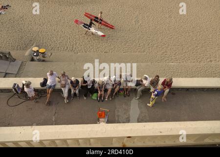 Biarritz, Francia, luglio 2023 mentre il sole tramonta, i turisti aspettano il loro autobus e i surfisti locali tornano a casa sulla Plage du Port Vieux, a Biarritz Foto Stock