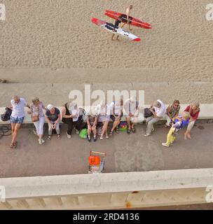 Biarritz, Francia, luglio 2023 mentre il sole tramonta, i turisti aspettano il loro autobus e i surfisti locali tornano a casa sulla Plage du Port Vieux, a Biarritz Foto Stock