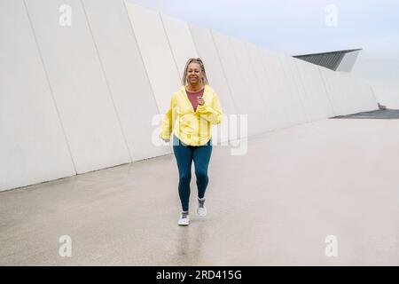Sport senior African Woman training mentre si corre al parco urbano - anziani concetto di stile di vita sano Foto Stock
