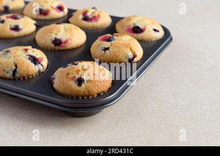 Gustosi cupcake di maffins di frutti di bosco ripieni di ribes nero o mirtilli. Dolci alla bacca sani fatti in casa. Cucina, panetteria. Foto Stock