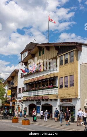 BANFF, CANADA - 5 LUGLIO 2023: Turisti di fronte al Clock Tower Village Mall su Banff Avenue nelle Montagne Rocciose canadesi. Segue l'edificio simbolo Foto Stock