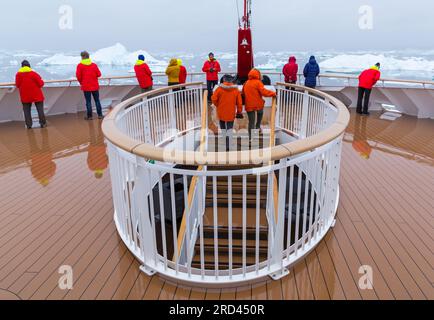 I turisti alla reception della nave da crociera Hurtigruten MS Fridtjof Nansen ammirano gli iceberg di Disko Bay, Groenlandia occidentale a luglio Foto Stock