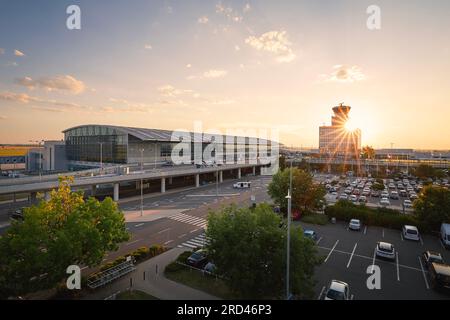 Praga, Repubblica Ceca - 15 luglio 2023: Edificio del terminal e torre di controllo del traffico aereo presso l'aeroporto Vaclav Havel di Praga al tramonto. Foto Stock