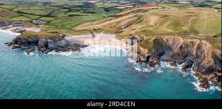 Vista panoramica aerea di Church Cove con la sua storica chiesa e Dollar Cove a Gunwalloe in Cornovaglia al tramonto Foto Stock