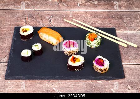 Piatto di ardesia con una selezione di sushi panini vegani Foto Stock