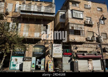 Vista orizzontale di alcuni edifici su una strada di Mea Shearim, uno dei più antichi quartieri ebraici di Gerusalemme Ovest, popolato da ebrei haredi Foto Stock