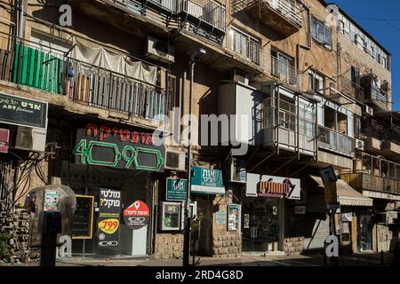 Vista orizzontale di alcuni edifici su una strada di Mea Shearim, uno dei più antichi quartieri ebraici di Gerusalemme Ovest, popolato da ebrei haredi Foto Stock