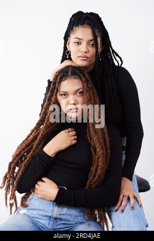 I capelli lunghi e naturali sono ciò che amano. Foto in studio di due bellissime giovani donne in posa su uno sfondo grigio. Foto Stock