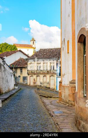 Strade acciottolate tra chiese barocche storiche e case in stile coloniale nella città di Ouro Preto nel Minas Gerais Foto Stock