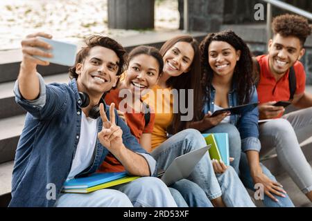 Selfie dello studente. Gruppo multietnico di amici del college che scattano foto insieme su smartphone Foto Stock
