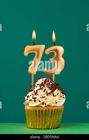 Candela di compleanno numero 73 - carta anniversario verticale con sfondo verde Foto Stock