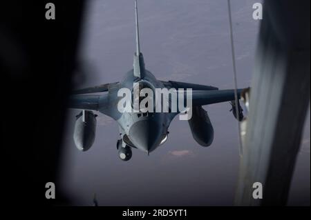 UN U.S. Air Force F-16 Fighting Falcon, assegnato al 457th Expeditionary Fighter Squadron, si avvicina a un KC-10 Extender, assegnato al 908th Expeditionary Air Refueling Squadron, durante operazioni di rifornimento aereo sopra gli Stati Uniti Central Command area of Responsibility, 6 luglio 2023. Il KC-10 Extender consente alle risorse aeree di rimanere in aria per periodi più lunghi, massimizzando il tempo di pattugliamento e garantendo la stabilità regionale. (STATI UNITI Foto dell'aeronautica militare del Senior Airman Jacob Cabanero) Foto Stock