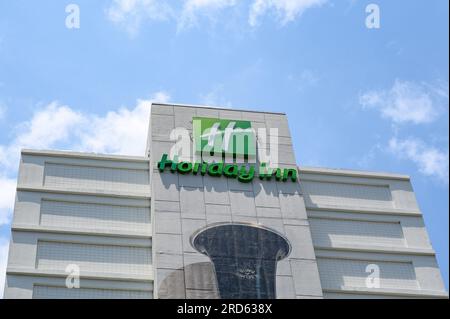 NEW ORLEANS, LOS ANGELES, USA - 2 LUGLIO 2023: Vista laterale della sezione superiore dell'Holiday Inn Hotel nel centro citta', con un cartello, il logo e la campana dipinta di un clarinetto Foto Stock