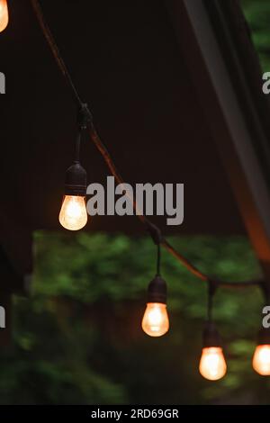 Primo piano della ghirlanda all'aperto con luce calda sul patio di una cabina di legno Foto Stock