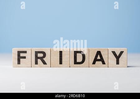 Testo venerdì su cubi di legno su sfondo blu. Giorno della settimana su blocchi di legno. Banner Web giorni della settimana. Calendario originale. Parte della serie. Concetto di tempo. Foto Stock