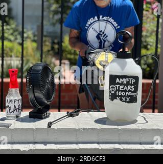 Hollywood, California, Stati Uniti 18 luglio 2023. Bottiglie spray riempite d'acqua e etichettate "AMPTP Tears 100 Proof", che sta per "The Alliance of Motion Picture and Television Producers (AMPTP)", sono accanto a un fan, il tutto per mantenere freschi i picchettatori mentre gli attori di Hollywood si uniscono agli scrittori (che hanno colpito per due mesi) Il secondo giorno del SAG-AFTRA Screen Actors Guild Strike, di fronte alla sede centrale di Netflix e ai Sunset Studios di Hollywood, CALIFORNIA. Gli spiriti erano alti nonostante l'allarme Extreme Heat in corso a Los Angeles, e i temperamenti caldi sulla percezione dell'avidità aziendale e del fai C. Foto Stock