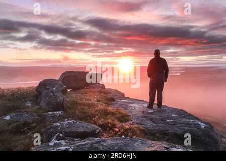 Teesdale, contea di Durham, Regno Unito. 19 luglio 2023. Meteo Regno Unito. Questa mattina, questo camminatore si è alzato presto per ammirare una spettacolare alba sui North Pennines a Teesdale, nella contea di Durham. Quando la nebbia non è uniforme, si prevede una mattinata asciutta, ma nuvole e docce si svilupperanno durante tutto il pomeriggio. Crediti: David Forster/Alamy Live News Foto Stock