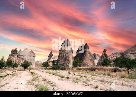 Splendido paesaggio in pietra della Cappadocia e vecchia casa grotta con tour a cavallo nel parco nazionale di Goreme al tramonto della Turchia. Foto Stock