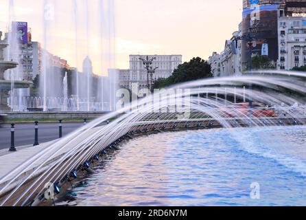 Crepuscolo sulle graziose fontane di Unirii Boulevard, che conducono al Parlamento del popolo, a Bucarest, in Romania Foto Stock