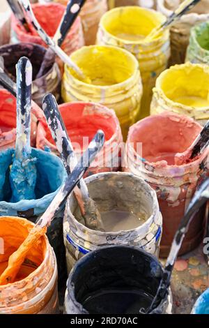 Grande gruppo di vecchie lattine di vernici multicolore aperte, ritaglio verticale, sfondo artistico astratto Foto Stock